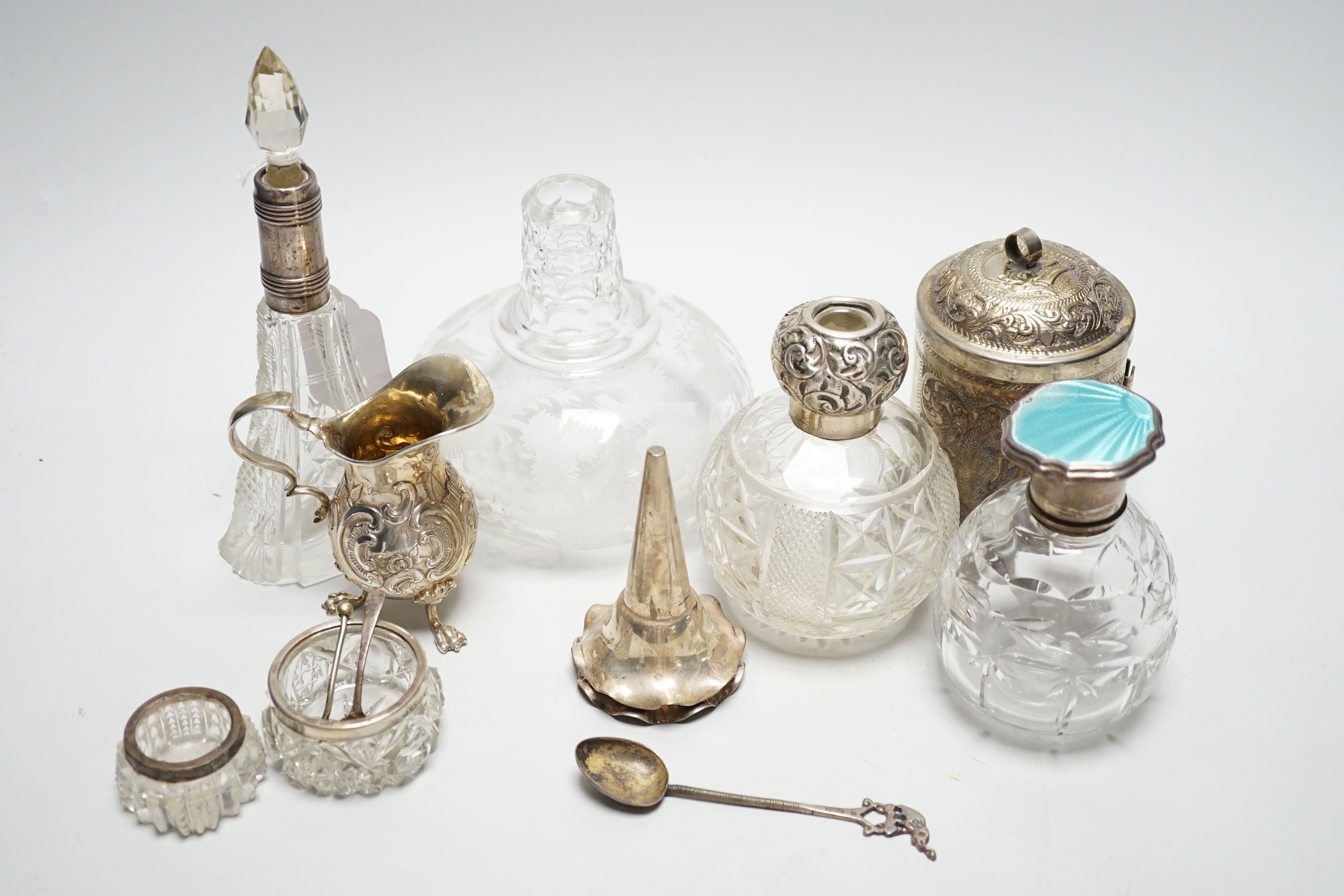 Sundry items including a German 800 white metal cream jug, three mounted glass scent bottles including silver and enamel, Indian white metal cannister, etched glass decanter, etc.